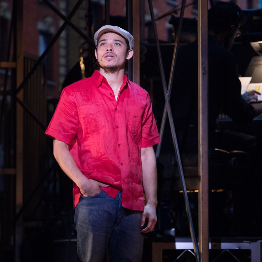 Anthony Ramos on stage in a red shirt and white cap